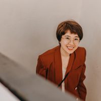 电影在线内容策划林恩的插画，短发戴耳环，面前放着平板和咖啡，背景有电影胶片元素